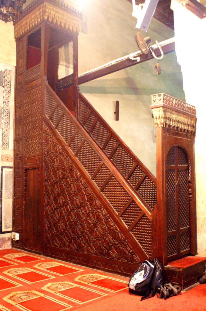 Minbar (pulpit) next to the main mihrab (prayer niche) in the moaque's main hall. with unphotogenic backpack and sandals. The mihrab